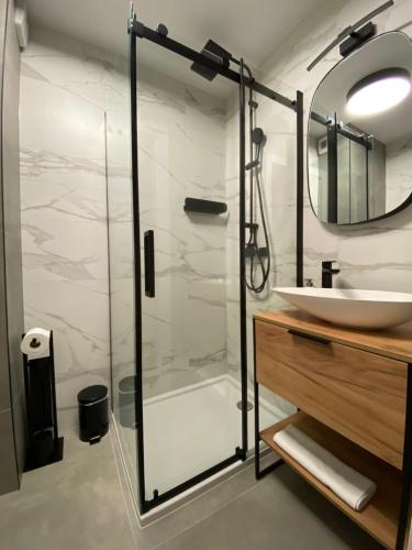 a bathroom with a glass shower and a sink at Vistula Avenue Apartment Free Parking in Krakow