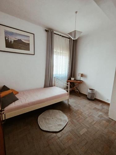 1 dormitorio con cama, ventana y alfombra en Great apartment, en Figueira da Foz