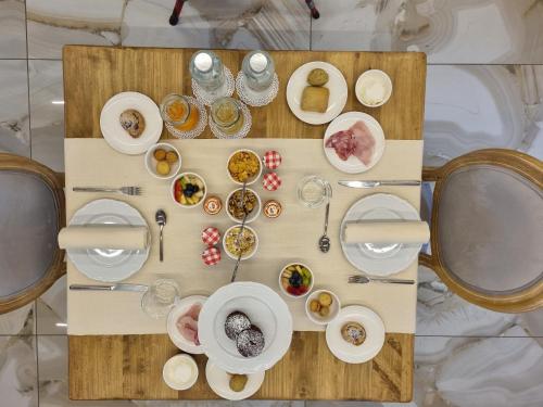 a table with plates and bowls of food on it at Villa Nonna Cicci Boutique Hotel - SPA in Cisterna dʼAsti