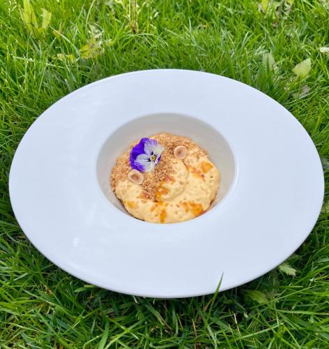 a white plate with a flower on top of the grass at Villa Nonna Cicci Boutique Hotel - SPA in Cisterna dʼAsti