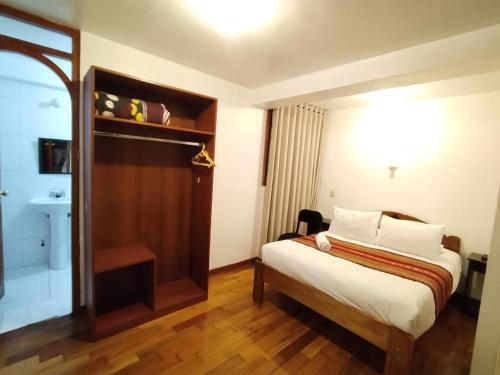 a hotel room with a bed and a bathroom at Paqarina San Blas in Cusco