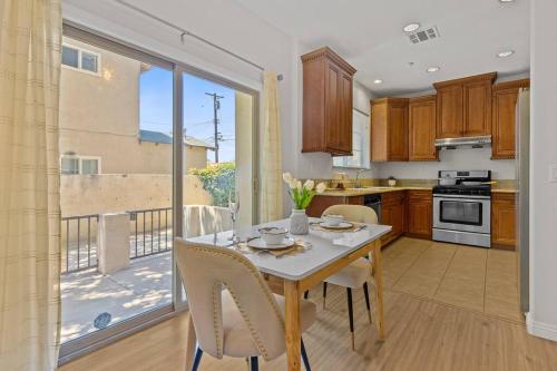 a kitchen with a table with chairs and a balcony at modern design home near disneyland in Fullerton