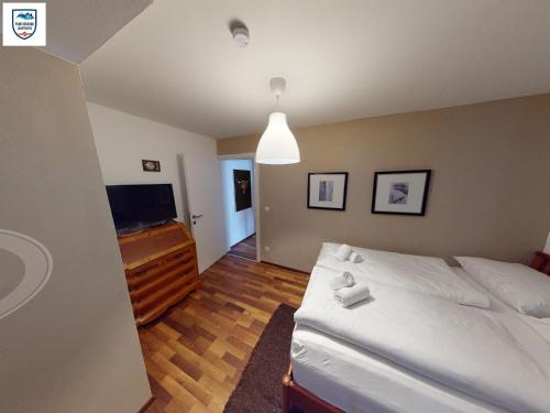 Apartmant Alpin - Top 1 by Four Seasons Apartments في كابرون: غرفة نوم بسرير وتلفزيون بشاشة مسطحة