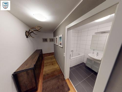 Apartmant Alpin - Top 1 by Four Seasons Apartments في كابرون: حمام مع حوض وحوض استحمام ومرحاض