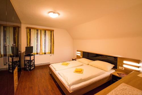 a bedroom with a large bed with two yellow folders at Gästehaus Leypold in Murau