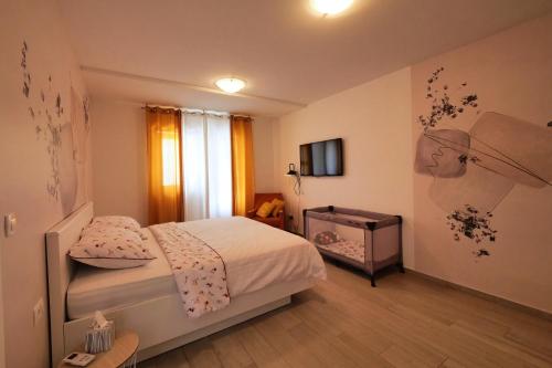 a small bedroom with a bed and a television at Dubrovnik Airport Apartment Pascal in Močići