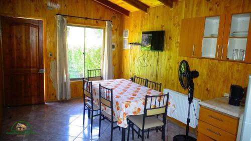 a dining room with a table and chairs and a window at Cabañas Buenavista Quillón in Quillón