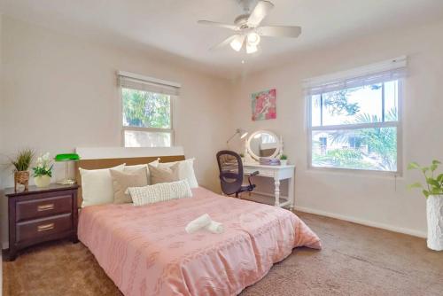 a bedroom with a bed with a ceiling fan and a desk at Entire Private Cozy 3-Bedroom House, 10 mins San Diego Gaslamp in National City