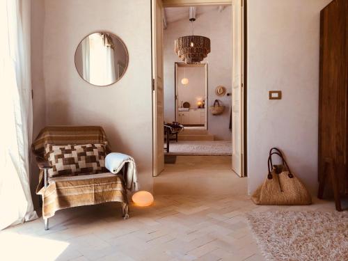 a hallway with a chair and a mirror in a room at Casa Imayah in Noto