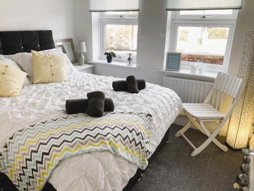- une chambre avec un grand lit et une chaise dans l'établissement The Sashes - Apartment One - FREE Parking - Ultrafast WIFI - Smart TV - Netflix - sleeps up to 6! Close to Poole Town Center & Sandbanks & Bournemouth, à Poole