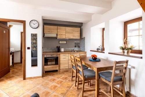 kuchnia z drewnianym stołem i krzesłami w obiekcie Apartmán v centru w mieście Česká Lípa