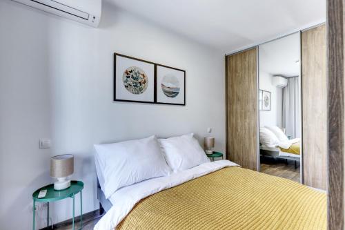 um quarto branco com uma cama e um espelho em STAR stylish flat in a modern neighborhood em Bratislava