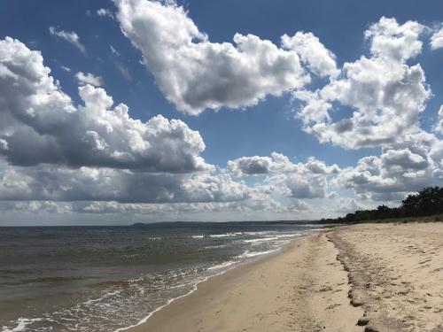 a beach with a cloudy sky and the ocean at Villa Brösarp - Villa Brösarp in Brösarp
