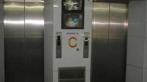 a row of elevators with a c sign on the wall at Philippine Hostel in Hong Kong