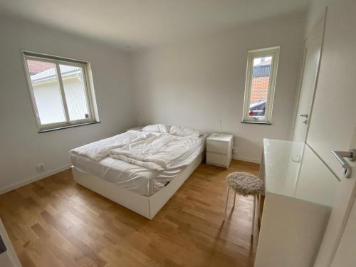 1 dormitorio blanco con 1 cama y 2 ventanas en Villa Brösarp - Villa Brösarp, en Brösarp