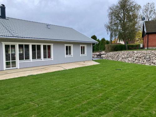 a house with a green lawn in front of it at Villa Brösarp - Villa Brösarp in Brösarp