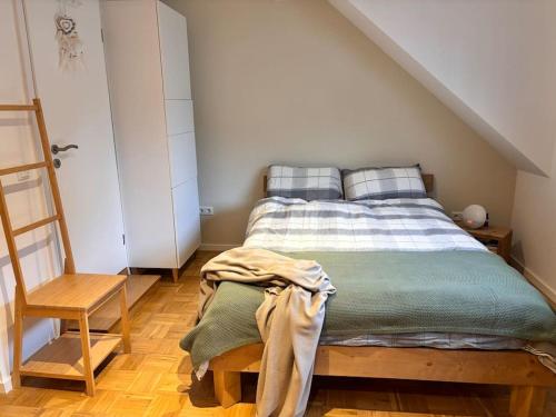 een slaapkamer met een bed en een houten stoel bij Ruhig & Gemütlich Nahe Frankfurt in Neu Isenburg