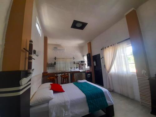 a small bedroom with a bed and a kitchen at Hostal Cann's House in Puerto Baquerizo Moreno