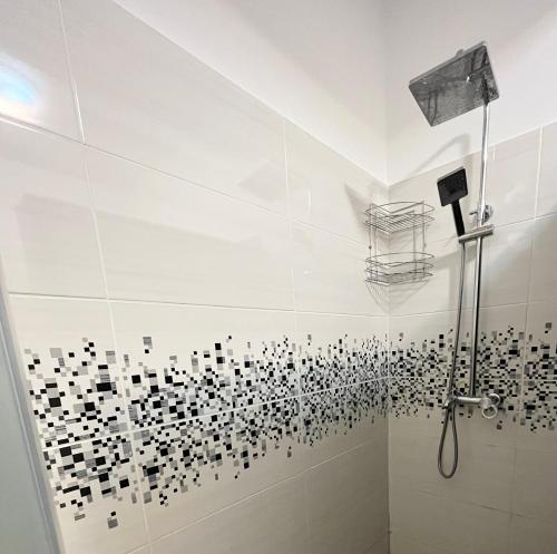een badkamer met een douche met zwarte en witte tegels bij Mamaia Nord cazare in Mamaia Nord – Năvodari