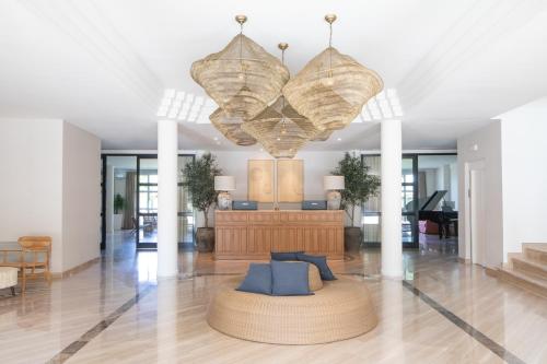 a living room with a couch and a chandelier at Hotel Sa Punta - Adults Only fr13 in Begur