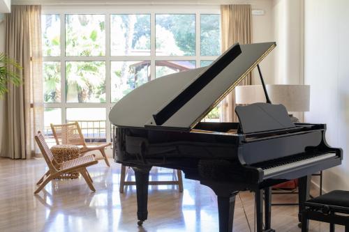 a black piano sitting in a living room at Hotel Sa Punta - Adults Only fr13 in Begur