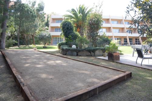 a park with a bench and bushes and a building at Hotel Sa Punta - Adults Only fr13 in Begur