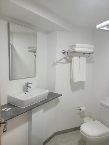 Baño blanco con lavabo y aseo en Hostal Bo Camiño, en Porriño