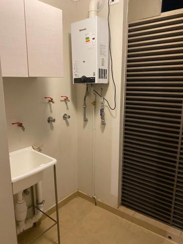 La salle de bains est pourvue d'un lavabo et d'un chauffe-eau. dans l'établissement Departamento para 6 personas amoblado, à Los Andes