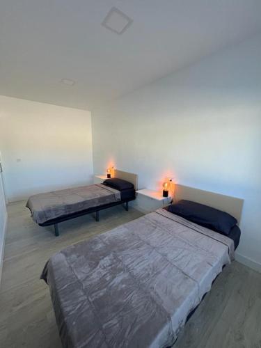 dwa łóżka w pokoju z dwoma lampami w obiekcie Villa Elche w mieście Elche