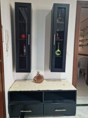 a room with two black cabinets and a table at Diar Tunis Carthage II in Ariana