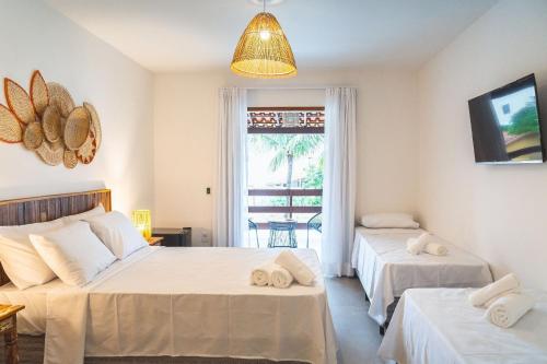 a bedroom with two beds and a window at Casa Dela Pousada in Cabo Frio