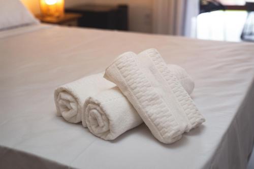uma pilha de toalhas sentadas numa cama em Casa Dela Pousada em Cabo Frio