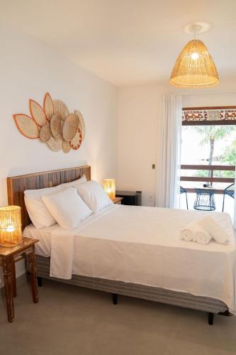 a bedroom with a large bed and a window at Casa Dela Pousada in Cabo Frio