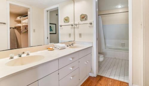 a white bathroom with a sink and a tub at 643 Newhaven in Fripp Island