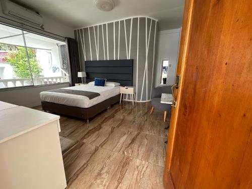 a bedroom with a bed and a desk and a window at Casa de Campo Hotel Majestic Yurimaguas in Yurimaguas