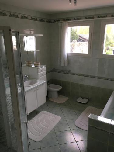 Un baño con lavabo, inodoro y ventana. en Agréable maison, en Pons