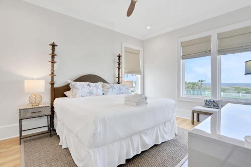 een witte slaapkamer met een bed en een raam bij Lil' Nauti in St. George Island