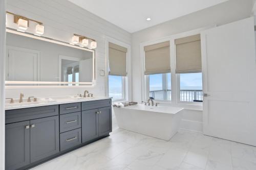 a white bathroom with a tub and a sink and a bath tub at Lil' Nauti in St. George Island