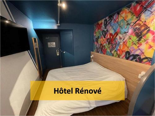 a bed in a room with a painting on the wall at Egg Hôtel Sarcelles in Sarcelles