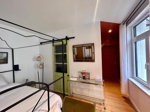 a bedroom with a bed and a mirror and a window at Maison Georges in Tourcoing