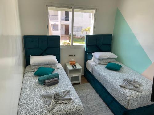 1 dormitorio con 2 camas y toallas. en Appartement Bousaid, en Oualidia