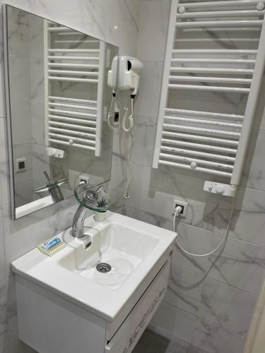 Baño blanco con lavabo y espejo en Appartement Bousaid, en Oualidia