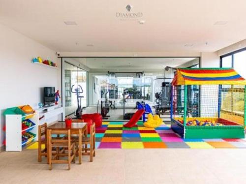 uma sala de estar com uma sala de jogos com um parque infantil em Flat Diamond 908 em São Lourenço