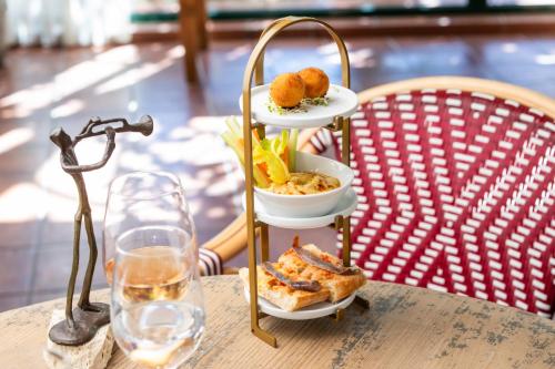 a plate of food on a table next to a glass of wine at Hotel Sa Punta - Adults Only fr13 in Begur