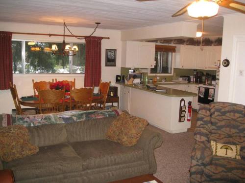 sala de estar y cocina con sofá y mesa en River House in Welches on Mt Hood OR, en Welches