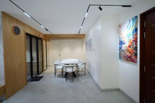 a table and chairs in a room with a painting at The Nova Heights in Kozhikode