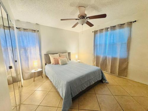 um quarto com uma cama e uma ventoinha de tecto em Deerfield Beach Retreat em Deerfield Beach