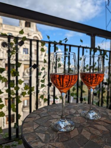 two glasses of wine sitting on a table on a balcony at Old Town Studio - Victoriei 2 in Bucharest