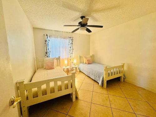 um quarto com 2 camas e uma ventoinha de tecto em Deerfield Beach Retreat em Deerfield Beach