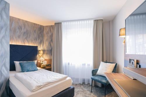 a hotel room with a bed and a desk at Hotel & Restaurant Rose in Bietigheim-Bissingen